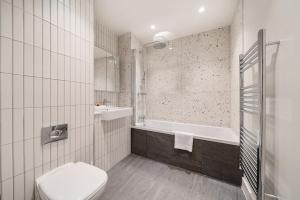 a bathroom with a toilet and a bath tub at Roomspace Serviced Apartments -Oasis Way in London +29 photos