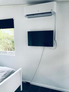 una TV a schermo piatto appesa a un muro in una camera da letto di Kungsgatan 36 a Borgholm