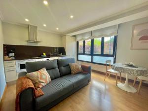 a living room with a couch and a table at Okai Etxea Bermeo, suite en el centro de la villa in Bermeo