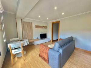 a living room with a blue couch and a table at Okai Etxea Bermeo, suite en el centro de la villa in Bermeo