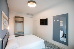 a small bedroom with a bed and a mirror at Fontanelle Seaside in Fontanelle