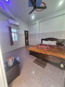 Un dormitorio con una cama y un ventilador de techo. en Shri Ladli Ji Guest House, en Chhatikara