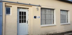 a house with a white door and two windows at La Maison d'Onésiphore in Cazes-Mondenard