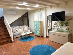 Una sala de estar con un sofá y un televisor. en Finca Los Llanos By Solymar Holiday, en Los Puertas