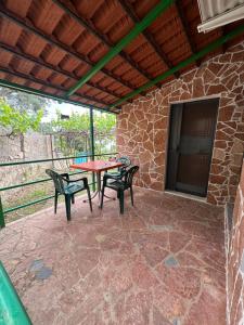 a patio with a table and chairs and a tv at Romeo’s Guest House 2 in Piqeras