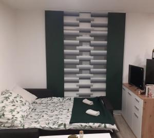 a bedroom with a bed with a green and gray wall at Vikendica Mihajlovic TUL in Čifluk