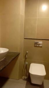 une salle de bain avec des toilettes blanches et un lavabo dans l'établissement Hotel Vintage Classic, à Coimbatore