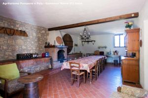 a kitchen and dining room with a table and a fireplace at Agriturismo Pompone e Pola in Gambassi Terme