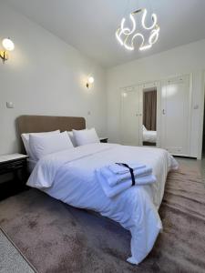 a bedroom with a large white bed with towels on it at Appartement spacieux - BD Anfa in Casablanca