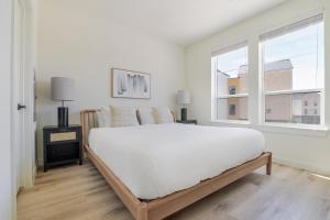 a white bedroom with a large bed and two windows at Blueground Round Rock pool nr Brushy Creek ATX-319 in Austin +21 photos