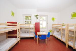 a room with several bunk beds and a table and chairs at Westend City Hostel in Vienna