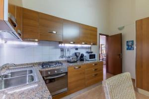 a kitchen with wooden cabinets and a sink at Porto Antigo 1 - Three Bedroom, Pool & Wifi in Santa Maria