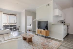 a white living room with a couch and a table at Blueground Sherman Oaks view nr Griffith Park LAX-1361 in Los Angeles