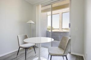a white table and chairs in a room with a window at Blueground Sherman Oaks view nr Griffith Park LAX-1361 in Los Angeles
