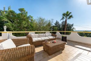 eine Terrasse mit Korbsofas und einem Tisch in der Unterkunft Casa Federica by Algarve Holidays in Santa Bárbara de Nexe