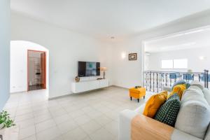 ein Wohnzimmer mit Sofa und Fernseher in der Unterkunft Casa Federica by Algarve Holidays in Santa Bárbara de Nexe