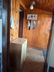 ein Badezimmer mit einer Holzwand und einem Spiegel in der Unterkunft Taša i Miki in Vrdnik