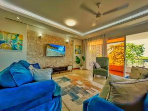 a living room with a blue couch and a fireplace at Nyali Luxury Apartments, Antalya in Mombasa