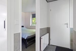 a bedroom with a bed and a mirror at Boshuis-Rust-Sauna in Een