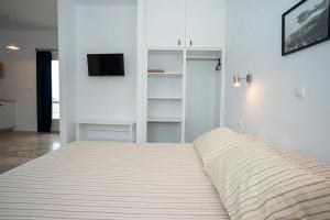 トロにあるDaphne Bungalowsのテレビ付きの部屋にある大きなベッド