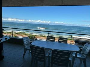 a table and chairs on a balcony with the ocean at Elegant Family Retreat with Ocean Views in Umdloti