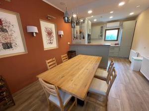 a kitchen and dining room with a wooden table and chairs at See Haus - Podmaniczky Szállás, Bor, Balaton in Balatonföldvár