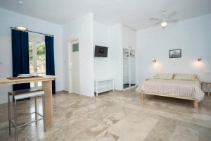 トロにあるDaphne Bungalowsのベッドとテーブルのある白い部屋