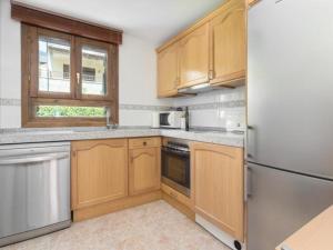 una cucina con mobili in legno e un frigorifero in acciaio inossidabile di Campanal de Izas a Villanúa