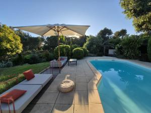 a patio with an umbrella and a swimming pool at Le Repaire de la Cadière à 5mn des plages ! in Saint-Cyr-sur-Mer