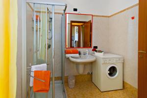 a bathroom with a shower and a sink and a washing machine at Miki House in Bergamo