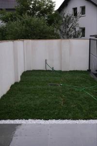 a yard with a fence and a green hose at Apartments Emona FREE Parking & gym in Ljubljana