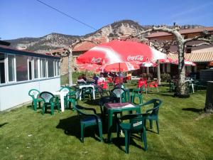 un grupo de mesas y sillas con un paraguas de cocacola en Hotel Rural el Arco, en Pesquera de Ebro