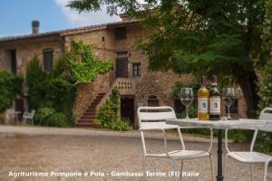 a table with two bottles of wine and two chairs at Agriturismo Pompone e Pola in Gambassi Terme