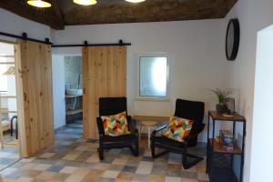a living room with two chairs and a table at Alojamento Antonio in Castanheira de Pêra
