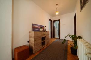 a living room with a television on a wooden dresser at Akác Apartmanház in Odorheiu Secuiesc