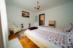 a bedroom with two beds and a chair in it at Akác Apartmanház in Odorheiu Secuiesc