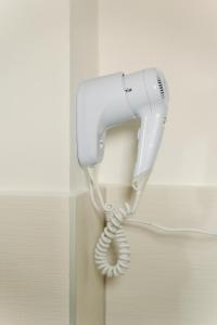 a white hair dryer hanging from a wall at Akác Apartmanház in Odorheiu Secuiesc