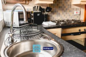 a kitchen sink with a bird cage on it at 3 Bedroom House By Escape & Estates Short Lets & Serviced Accommodation Birmingham With Patio & Garden in Birmingham +7 photos