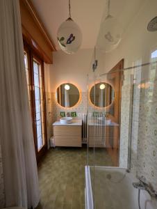 a bathroom with two sinks and a tub and two mirrors at Iseo Lake Terrace in Sale Marasino +62 photos