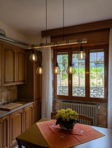 a kitchen with a table with a vase of flowers on it at Iseo Lake Terrace in Sale Marasino