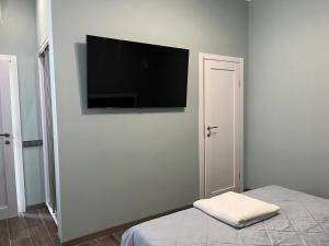 a bedroom with a flat screen tv on a wall at Green Hall Hotel in Izmail