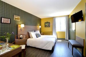 Habitación de hotel con cama y escritorio en Hôtel de France, en Ornans