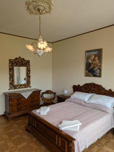 a bedroom with a bed and a mirror and a chandelier at Iseo Lake Terrace in Sale Marasino