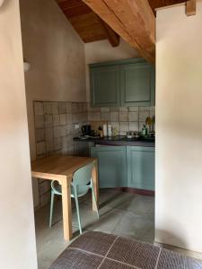 a kitchen with blue cabinets and a wooden table at Alte terre lab&room in San Damiano Macra