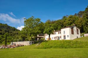 a large white house on a hill with a field at Casale la Poiana in Lucca