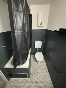 a bathroom with a toilet and a tub and a shower at SpeedStay - Duisburg Marxloh in Duisburg