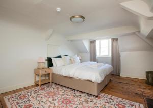 a bedroom with a large bed and a rug at Luxurious Town Centre Apartments in Cirencester