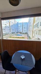 Una mesa y sillas en una habitación con una ventana grande. en Luxury Getaway - Pool View, en Agadir