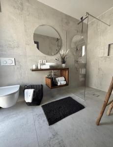 a bathroom with a tub and a sink and a mirror at Stylish Unit in Komarna - Idyllic Retreat in Komarna
