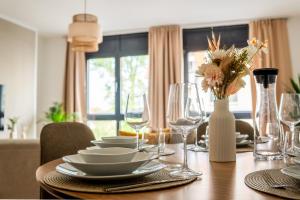 ein Esstisch mit Tellern und Weingläsern in der Unterkunft Luma-Living Apartments in Dresden + 26 Fotos